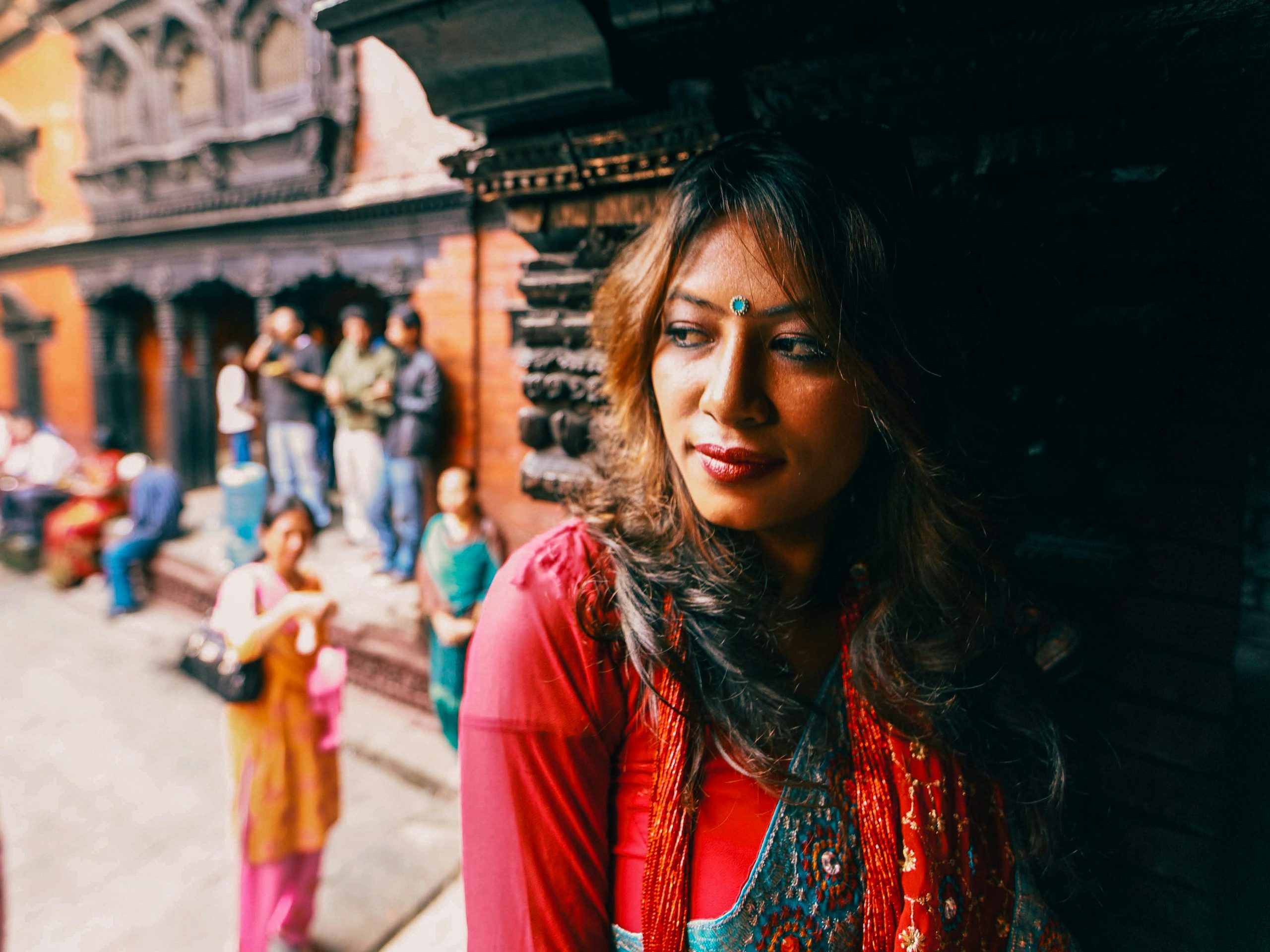 A captivating portrait of a woman in traditional attire outside an ancient building.
